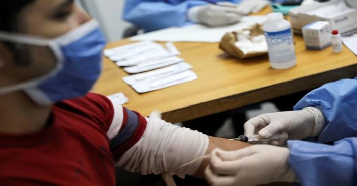 FILE PHOTO: Medical workers take blood samples from a man for a coronavirus disease (COVID-19)