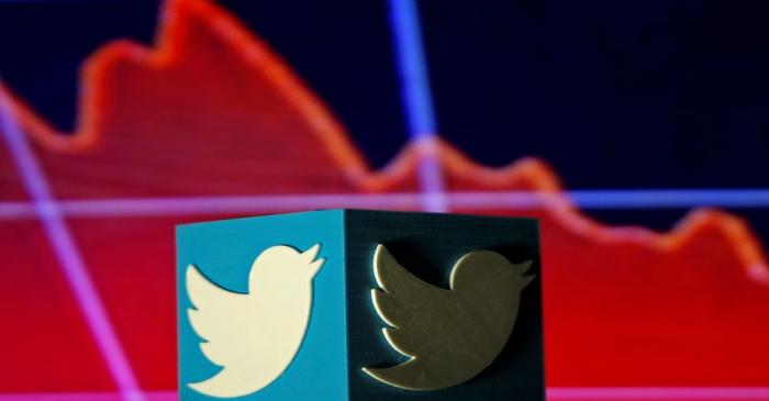 FILE PHOTO: A 3D printed Twitter logo is seen in front of displayed stock graph in this