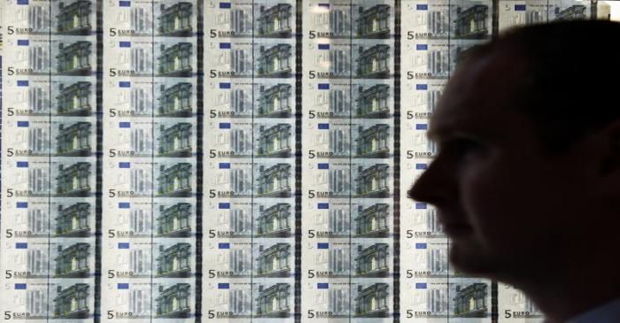 A man is seen in front of a sheet of five Euro notes at the opening of the new Central Bank of