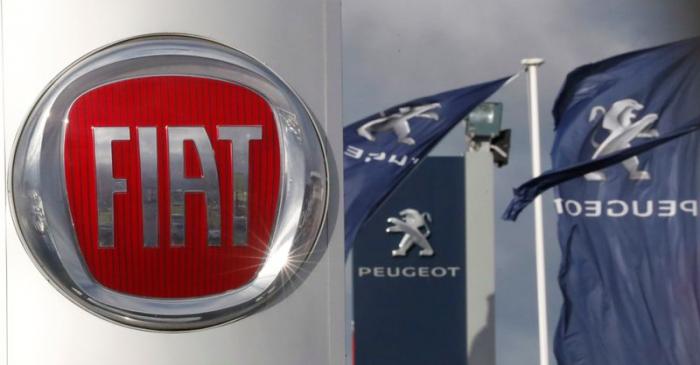 FILE PHOTO: The logos of car manufacturers Fiat and Peugeot are seen in front of dealerships of