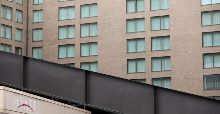 The window curtains are uniformily closed at a Hyatt hotel that is completely closed to guests