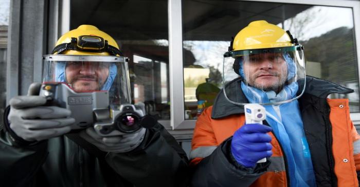 FILE PHOTO: Workers from the multinational ArcelorMittal pose with a thermal camera and a