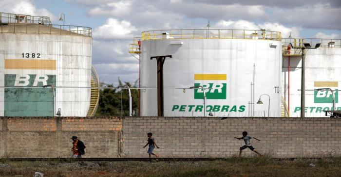 FILE PHOTO: People past in front of the tanks of Brazil's state-run Petrobras oil company in