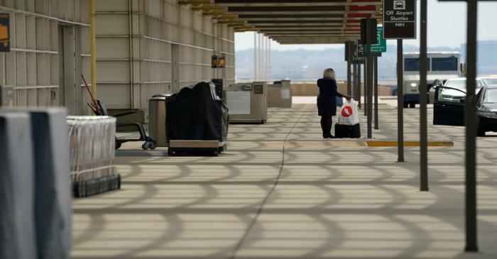 FILE PHOTO: Flight attendant waits alone outside Reagan National airport in Washington