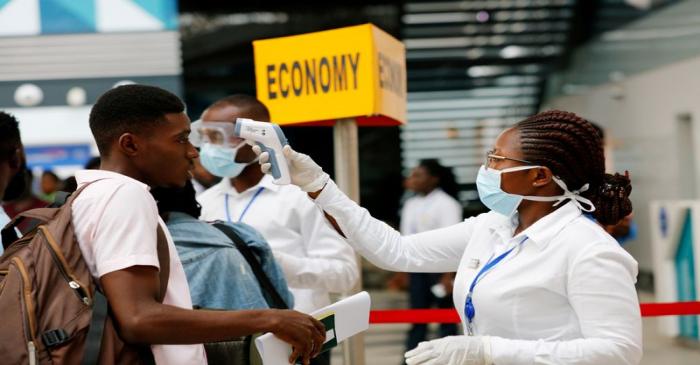 FILE PHOTO: A health worker checks the temperature of a traveller as part of the coronavirus