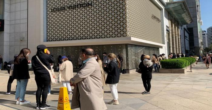 People queue to enter the Chanel boutique at a department store amid the coronavirus disease