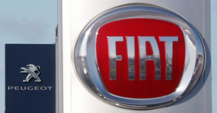 The logos of car manufacturers Fiat and Peugeot are seen in front of dealerships of the