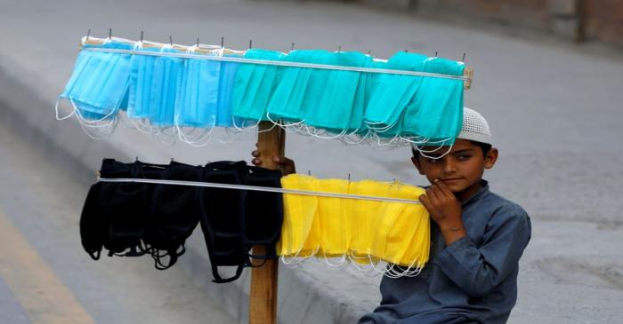 FILE PHOTO: Boy waits for customers to sell handmade masks in Peshawar