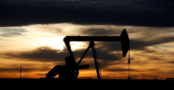 FILE PHOTO: The sun sets behind a crude oil pump jack on a drill pad in the Permian Basin in
