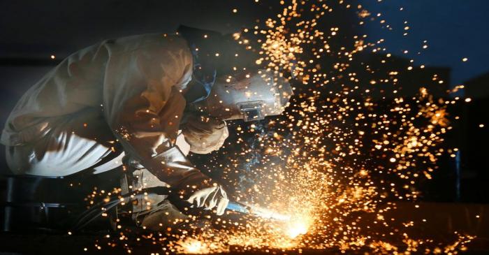 Worker works on a production line at a factory of a ship equipments manufacturer, in Nantong,