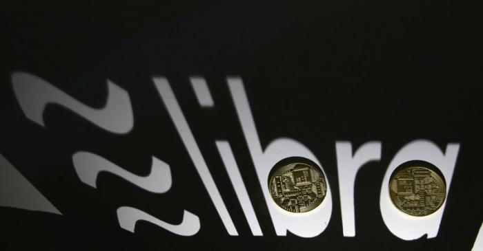 Shadow of a 3D-printed Facebook Libra cryptocurrency logo is seen near cryptocurrency