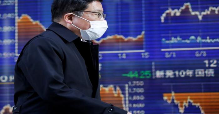 A passerby wearing a protective face mask, following an outbreak of the coronavirus, walks past