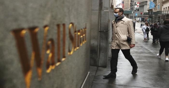 FILE PHOTO: A man wears a protective mask as he walks on Wall Street during the coronavirus