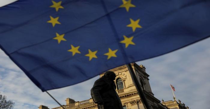 An European Union flag flies outside the Houses of Parliament in London near the statue of