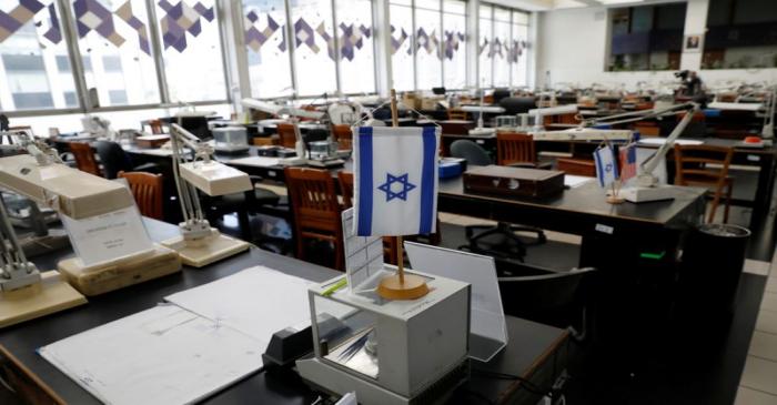 An Israeli flag is seen atop one of the empty trading tables at the diamond exchange floor,