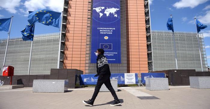 FILE PHOTO: A man wearing a face mask walks past the European Commission headquarters as the