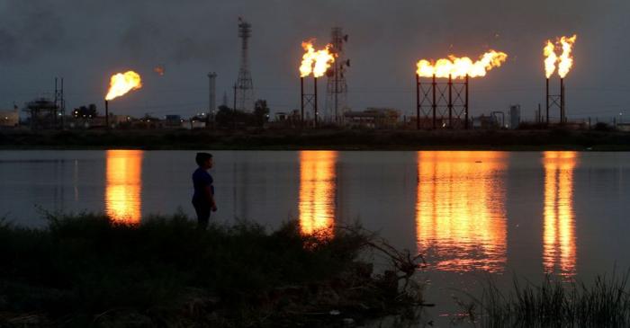 FILE PHOTO: Flames emerge from flare stacks at Nahr Bin Umar oil field, north of Basra