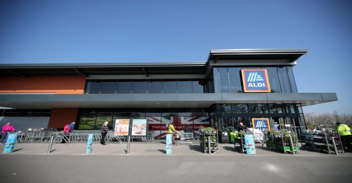 FILE PHOTO: People follow social distancing rules while they queue outside an Aldi store in