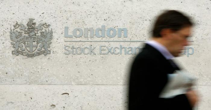 A man walks past the London Stock Exchange in the City of London