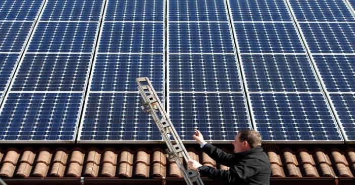 Michael Greif controls his 56 photovoltaic (solar) panels at the roof of his house in Coburg