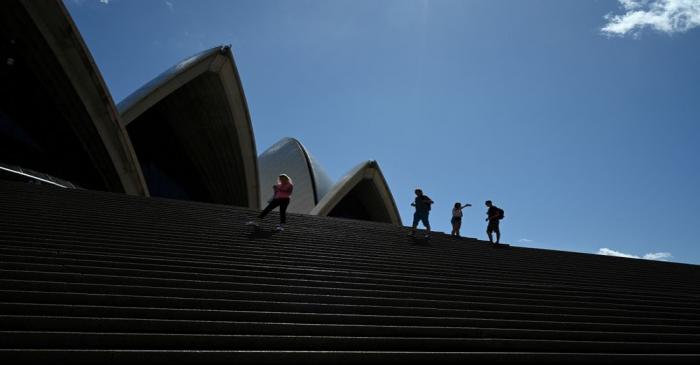 FILE PHOTO: A handful of tourists stand atop the mostly deserted steps of the Sydney Opera
