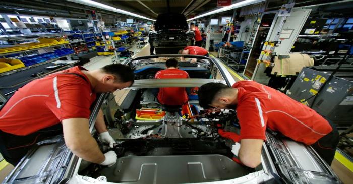 FILE PHOTO: Employees of German car manufacturer Porsche work on a Porsche 911 at the Porsche