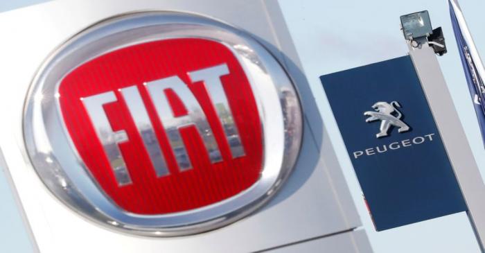 FILE PHOTO: The logos of car manufacturers Fiat and Peugeot are seen in front of dealerships of