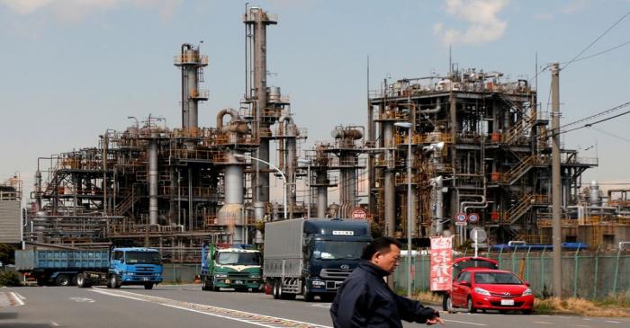 Worker walks near a factory at the Keihin industrial zone in Kawasaki