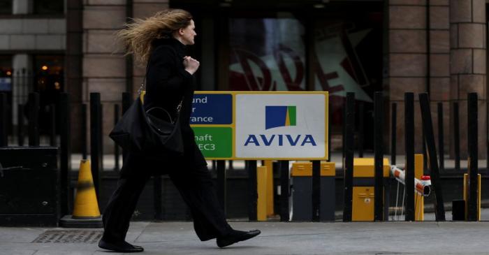 FILE PHOTO: A pedestrians walks past the Aviva logo outside the company head office in the city