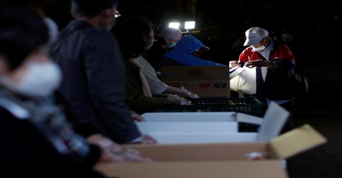 An elderly man receives food aid handouts, as the spread of the coronavirus disease (COVID-19)