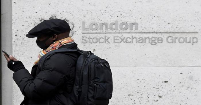 FILE PHOTO: A man wearing a protective face mask walks past the London Stock Exchange Group