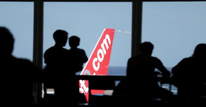 People look out at a Jet2.com aircraft from the departures area of Lanzarote Airport, in