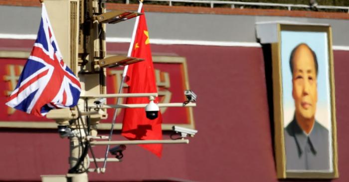 A Union flag and a Chinese flag are placed at a pole with security cameras in front of a