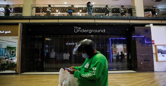 A food delivery rider uses his cellphone at a shopping mall, amid the coronavirus disease