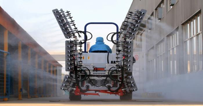 Worker operates a machine to spray disinfectants at an industrial park following an outbreak of
