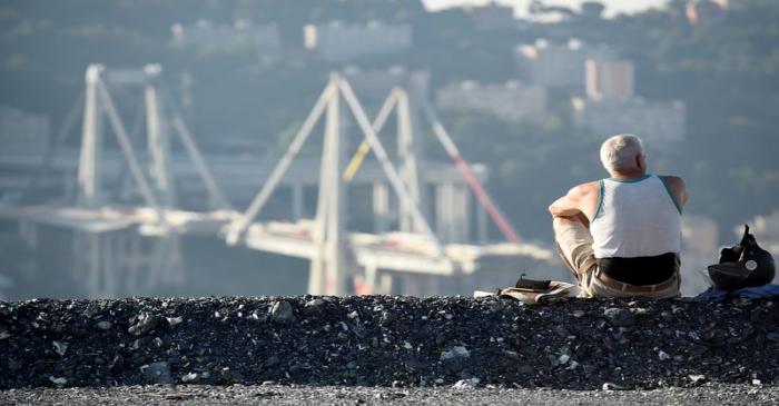 FILE PHOTO: A man looks at Morandi Bridge, before controlled explosions will demolish two of