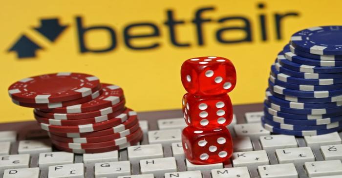 Betfair logo is seen behind a keyboard, gambling dice and chips in this illustration taken in
