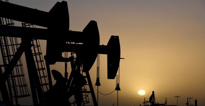 FILE PHOTO:  Pump jacks operate at sunset in Midland, Texas