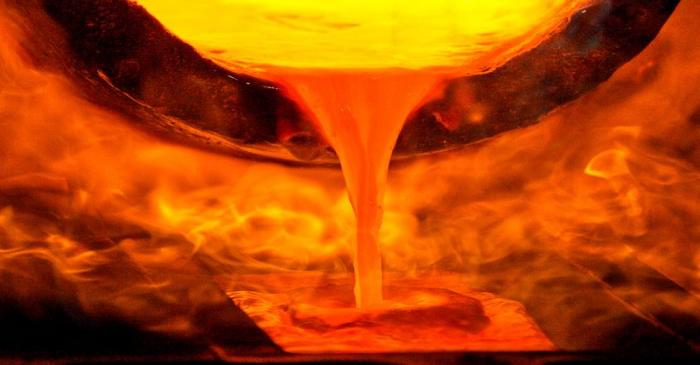 FILE PHOTO: Melted gold flows out of a smelter into a mould of a bar at a plant of gold refiner
