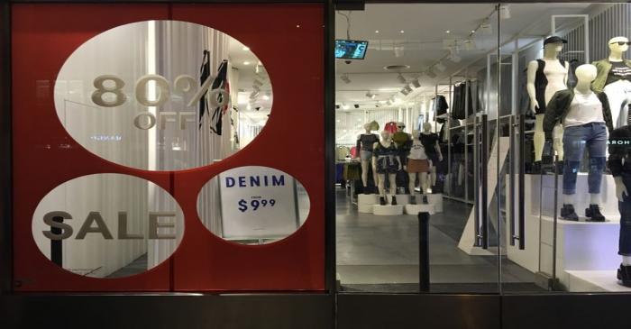 An H&M store has sale signs in the window in New York City