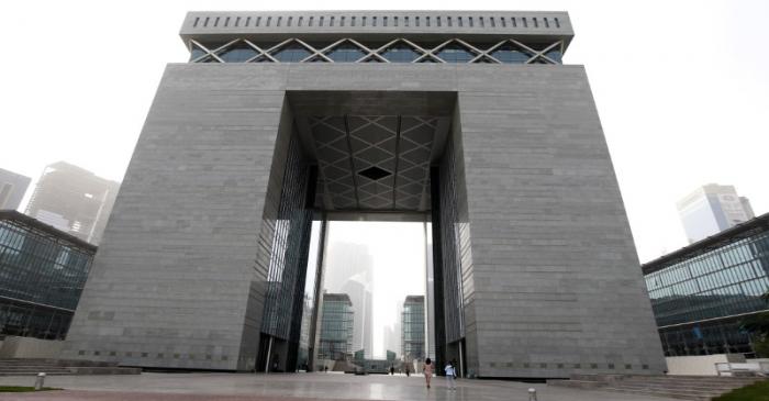 People walk near The Gate building at the financial and business district Dubai International