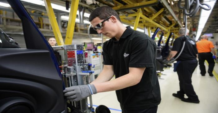 Workers assemble cars at the plant for the Mini range of cars in Cowley, near Oxford