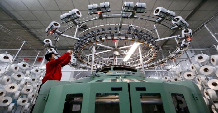 FILE PHOTO: Textile worker is seen on a fabric production line at a factory in Qingdao