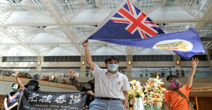 A pro-democracy demonstrator waves the British colonial Hong Kong flag during a protest against