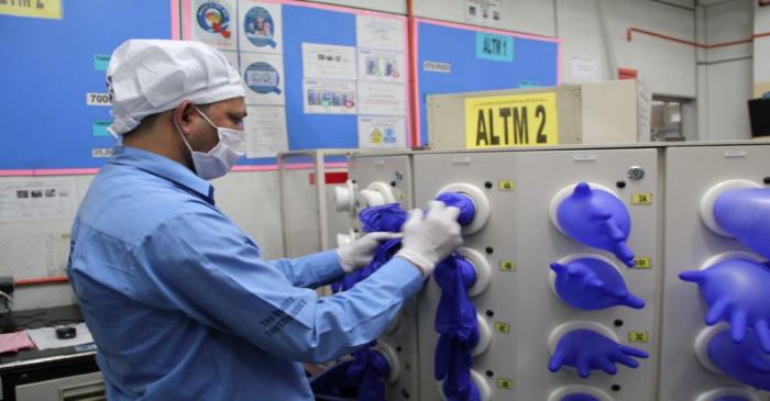 FILE PHOTO: A worker inspects newly made gloves at Top Glove factory in Klang