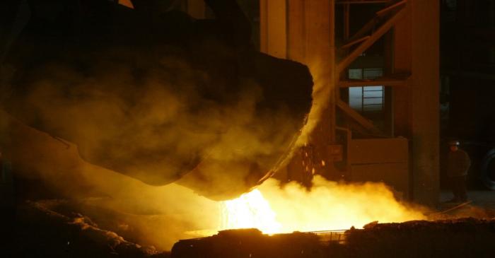 WORKER MONITORS A HUGE CAULDRON POuRING MOLTEN STEEL IN HANGZHOU.