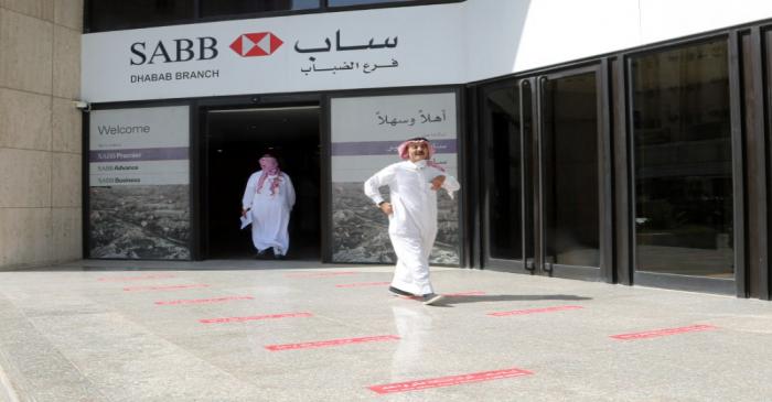 Saudi men are seen at SABB bank as the government eases lockdown restrictions amid the