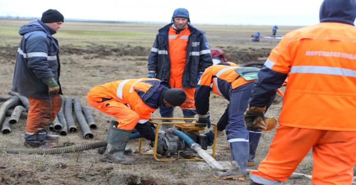 Rescuers work at the site of a huge leak of diesel fuel into the river after an accident at a