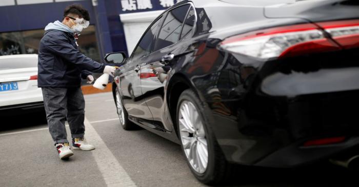 FILE PHOTO: Staff member disinfects a vehicle at a service centre of car-hailing service Didi