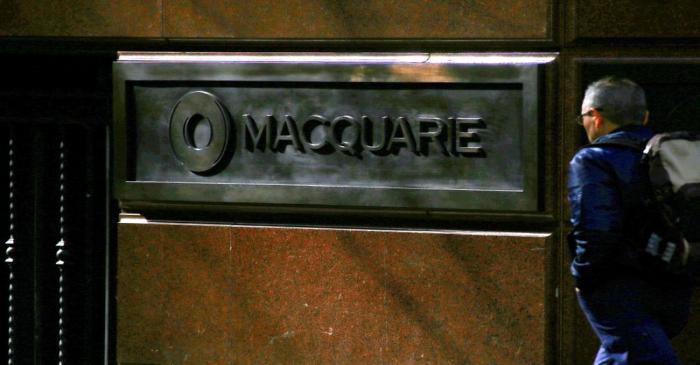 A pedestrian walks past the logo of Australia's biggest investment bank Macquarie Group Ltd